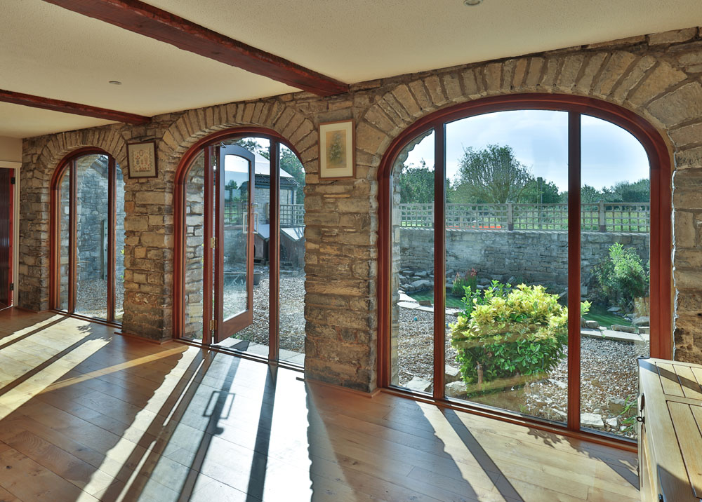 Wide-arch wooden door and window frames for a barn conversion